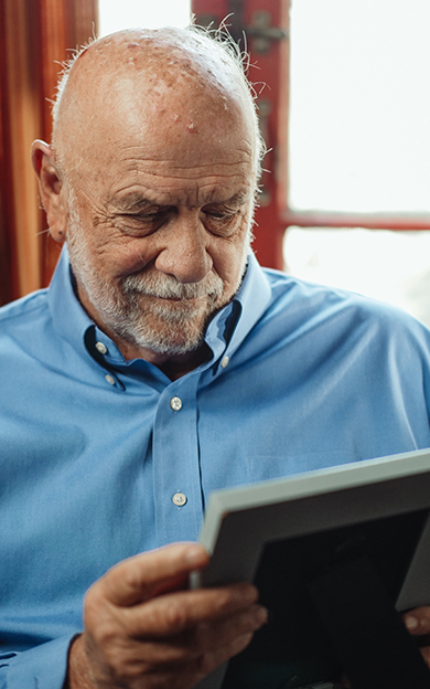 elderly man looking at photograph