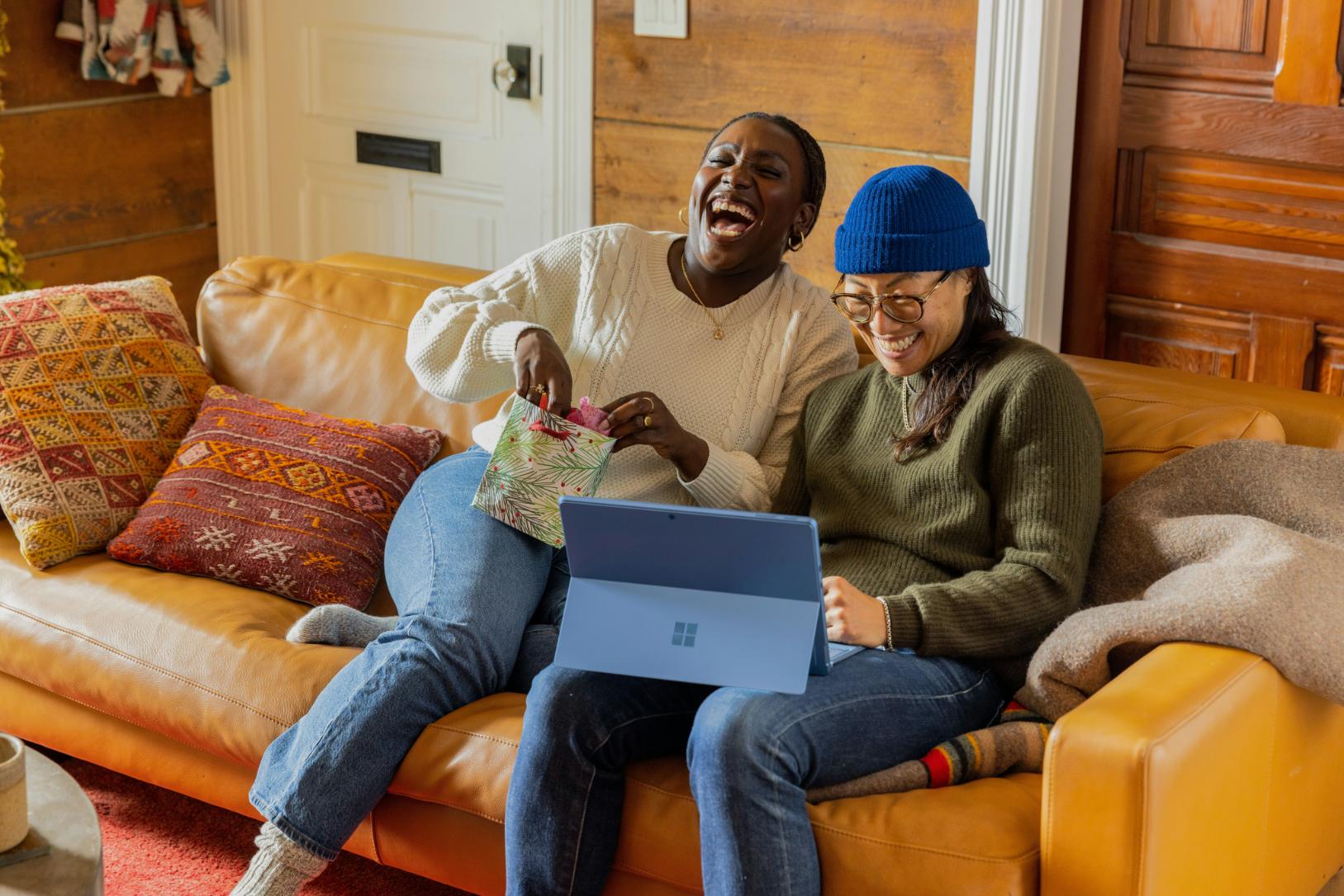 two people on a sofa laughing together