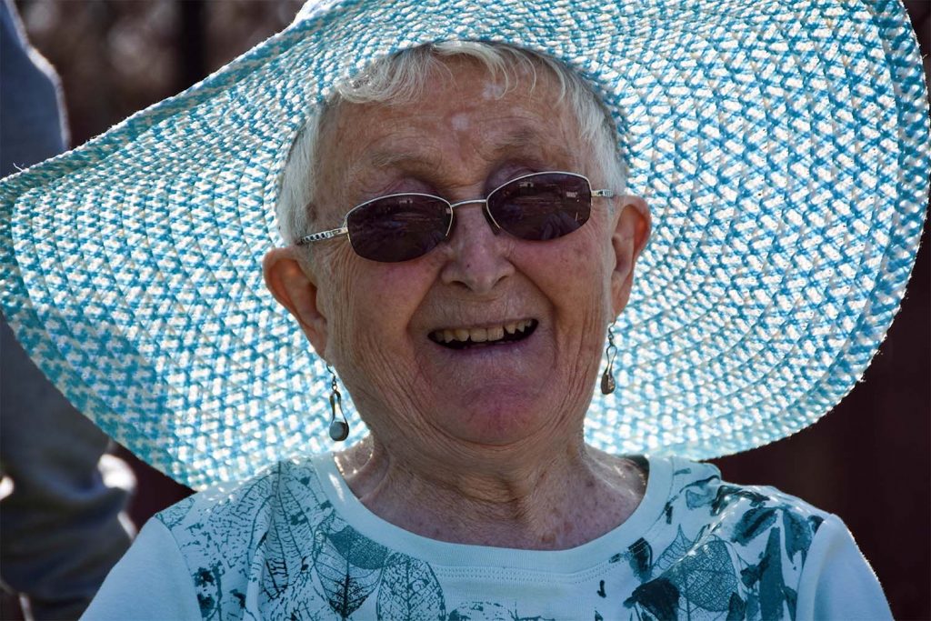 elderly woman smiling in a sun hat