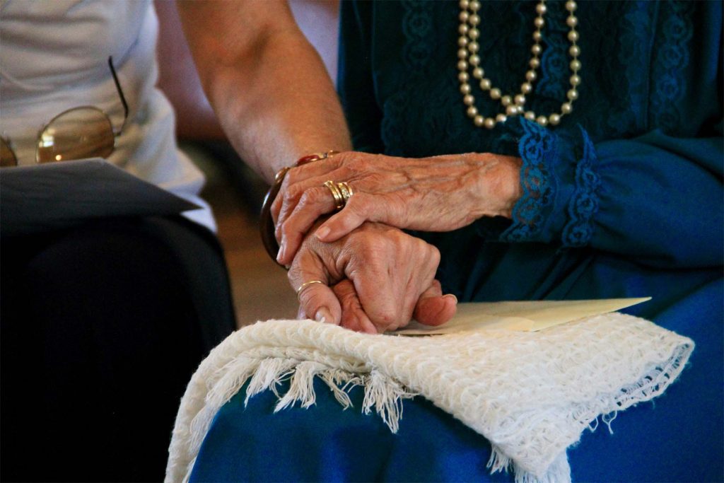 Elderly lady holding hands